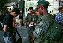 Altstadt, Jerusalem.<br><br>Ein Mann wird von israelischen Soldaten kontrolliert. <br><br>Juli 2004.<br><br>Photograph: David Gannon<br><br>E-mail: David.Gannon@gmx.de